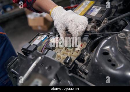 Female auto mechanic checking car parts in auto repair shop Stock Photo