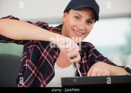 female technician using a screwdriver for fixing printer Stock Photo