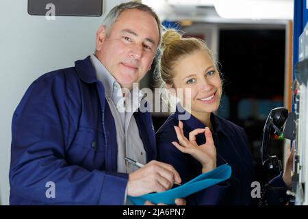 happy female apprentice doing an ok sign with mentor Stock Photo