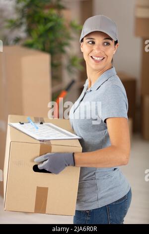 young deliverywoman wearing cap holding box Stock Photo
