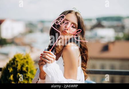 Happy bride celebrates bachelorette party, dancing and having fun on the roof of the house. Stock Photo