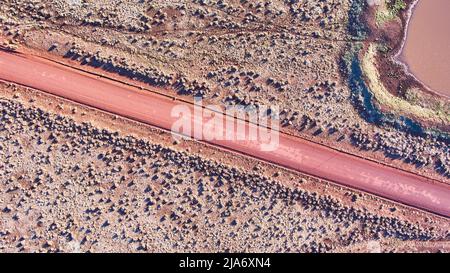 Aerial of red dirt road in desert plains Stock Photo