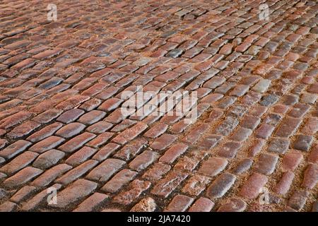 Detail texture asset of red brick road in shade at angle Stock Photo