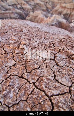 Badlands cracks in ground with canyons in distance Stock Photo