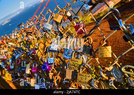 Chain linked fence covered in hundreds of locks by bay Stock Photo