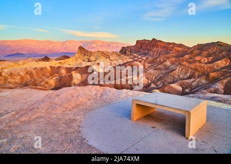 Bench to view sunrise of iconic Zabriskie Point at Death Valley with colorful waves Stock Photo