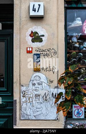 Street art paste-ups & graffiti on Facade Of Pauls Boutique in Oderberger Strasse,Prenzlauer Berg, Berlin, Germany. Stock Photo