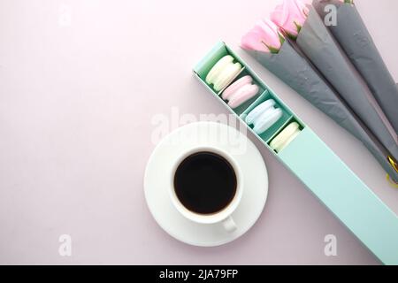 top view of macaroon in a paper box , tea and flower on table  Stock Photo
