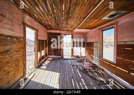 Inside abandoned and decaying wood room in desert Stock Photo