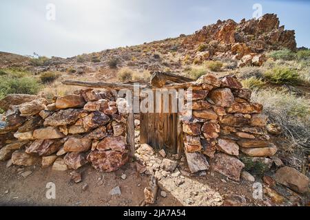 Desert hills with abandoned stone structure by old mine Stock Photo