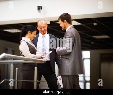 smiling business team discussing something in office Stock Photo
