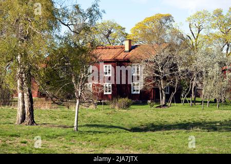 DALARNA, SWEDEN ON MAY 16, 2022. View of a red wooden building, park in the Swedish landscape. Editorial use. Stock Photo