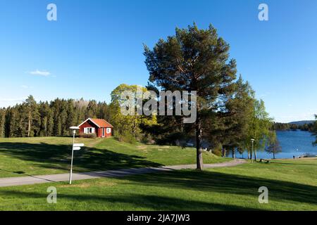 DALARNA, SWEDEN ON MAY 16, 2022. View of a red wooden building, park in the Swedish landscape. Editorial use. Stock Photo