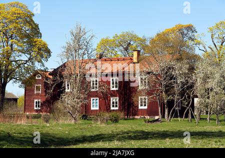 DALARNA, SWEDEN ON MAY 16, 2022. View of a red wooden building, park in the Swedish landscape. Editorial use. Stock Photo