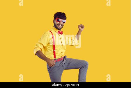 Funny happy cheerful young Indian guy celebrating, dancing and having fun at party Stock Photo