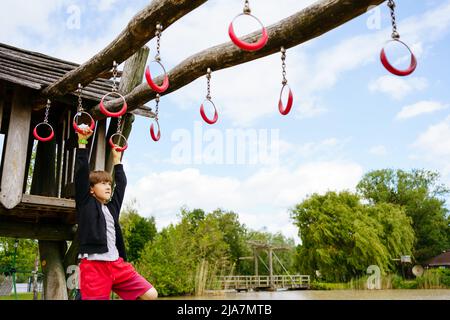 Climbing boy on the playground outside in center Parc in Niederlande  Stock Photo