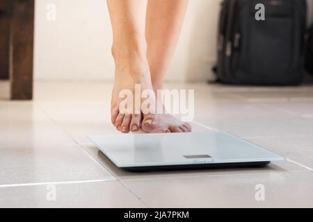 Woman bare feet standing on a digital scale with body fat analyzer that  uses bioelectrical impedance (BIA) to gauge the amount of fat in your body  Stock Photo