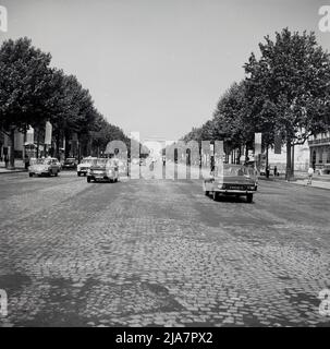 1960s, historical, Paris, France and a view from this era of the famous part cobbled boulevard, the Champ-Elysees, a long, broad tree-lined avenue that leads up to the Arc de Triomphe, the massive triumphal arch, which is an icon of the country. Stock Photo
