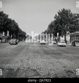 1960s, historical, Paris, France and a view from this era of the famous part cobbled boulevard, the Champ-Elysees, a long, broad tree-lined avenue that leads up to the Arc de Triomphe, the massive triumphal arch, which is an icon of the country. Stock Photo