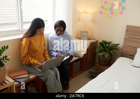 Female students in lounge clothes creating wireframe for college website Stock Photo