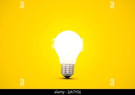 Glowing light bulb isolated on a bright yellow background. Stock Photo