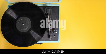 teal record player with a bright yellow background. Stock Photo