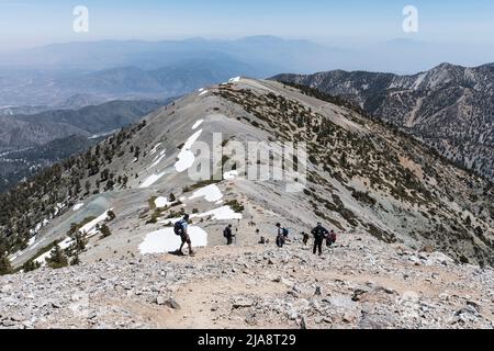 Mt Baldy, California, USA - May 22, 2022:  Hikers descending the Devils Backbone Trail on Mt Baldy in the San Gabriel Mountains near Los Angeles and O Stock Photo