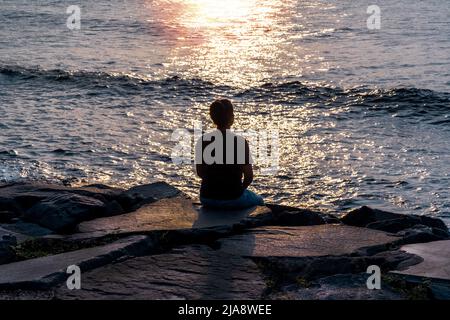 Indian Girl meditating at beach.