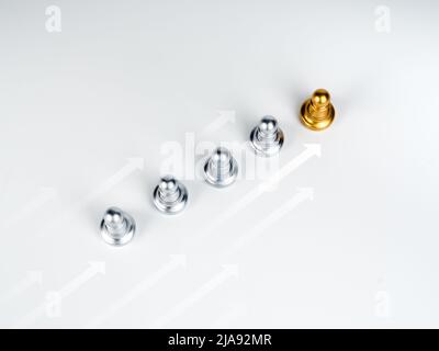 White rising moving arrows with the golden pawn chess piece, leading in front of the silver pawn chess pieces, followers on white background. Leadersh Stock Photo