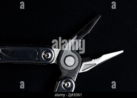 Close-up of Multi-tool pliers on black background Stock Photo
