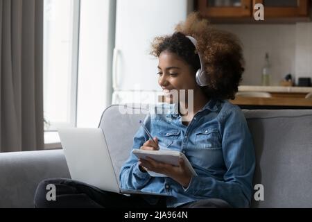 Happy engaged Back high school student girl in wireless headphones Stock Photo