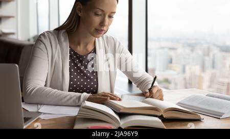 Serious hardworking millennial adult student preparing for exam Stock Photo