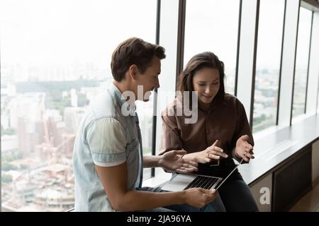 Engaged office coworkers discussing work project at brief meeting Stock Photo