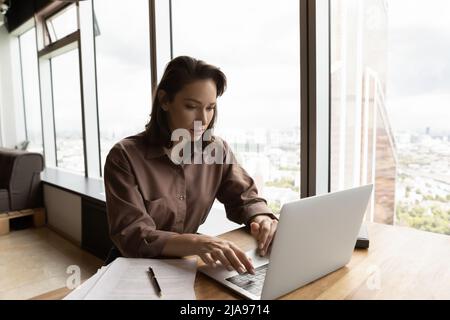 Focused remote employee working at laptop from home Stock Photo
