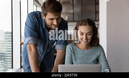 Happy employees working on project together, watching video presentation Stock Photo