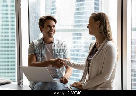 Happy female business leader hiring professional with laptop Stock Photo