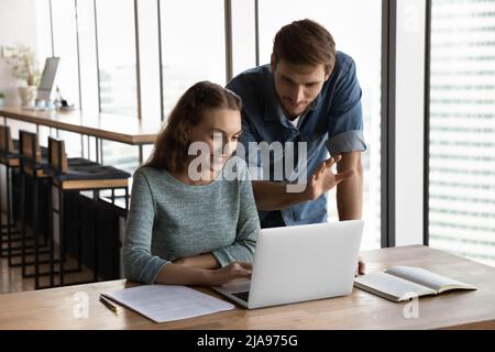 Corporate mentor teaching intern, giving advice, supervising work Stock Photo