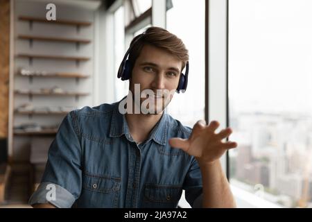 Positive confident millennial man in headphones working from home Stock Photo