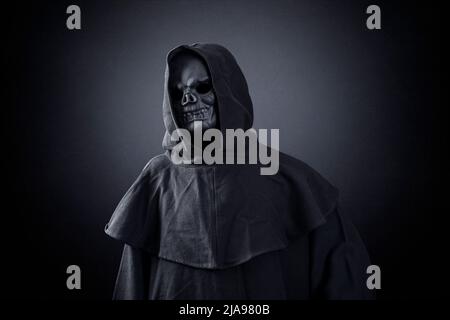 Grim reaper over dark misty background Stock Photo