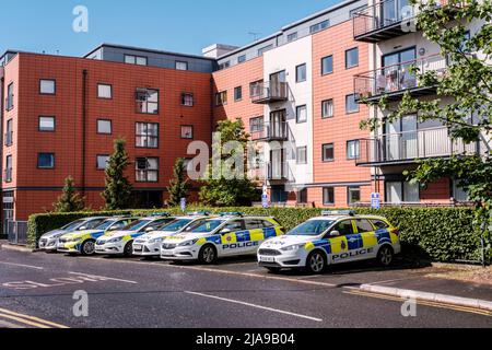 Epsom Surrey, London UK, May 24 2022, A Row Or Line Of Police Cars Parked Infront Of A Modern Residentail Apartment Building Stock Photo