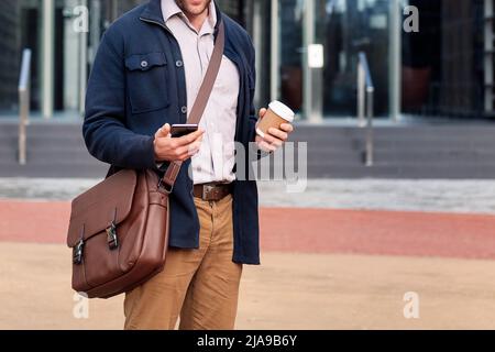 business man consulting phone in front of office Stock Photo