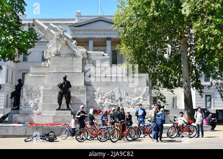 Tour guide on conducted guided tour group of men & women tourists hired bikes sightseeing Royal Artillery memorial Hyde Park Corner London England UK Stock Photo