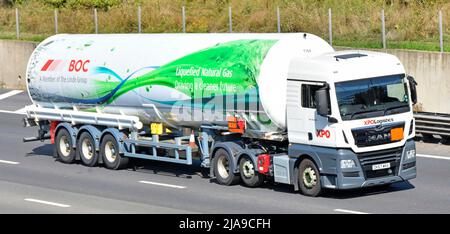 Front & side XPO logistics hgv MAN lorry truck driver & Linde BOC LNG liquefied natural gas delivery tanker trailer driving England UK motorway road Stock Photo