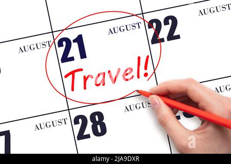 21st day of August. Hand drawing a red circle and writing the text TRAVEL on the calendar date 21 August. Travel planning. Summer month. Day of the ye Stock Photo