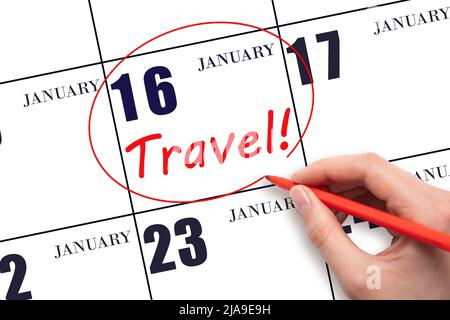 16th day of January. Hand drawing a red circle and writing the text TRAVEL on the calendar date 16 January. Travel planning. Winter month. Day of the Stock Photo