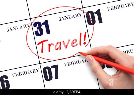 31st day of January. Hand drawing a red circle and writing the text TRAVEL on the calendar date 31 January. Travel planning. Winter month. Day of the Stock Photo