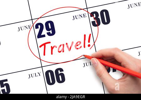 29th day of June. Hand drawing a red circle and writing the text TRAVEL on the calendar date 29 June. Travel planning. Summer month. Day of the year c Stock Photo