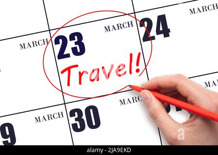 23rd day of March. Hand drawing a red circle and writing the text TRAVEL on the calendar date 23 March. Travel planning. Spring month. Day of the year Stock Photo