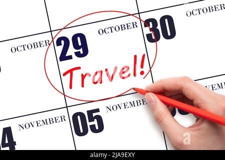 29th day of October. Hand drawing a red circle and writing the text TRAVEL on the calendar date 29 October. Travel planning. Autumn month. Day of the Stock Photo