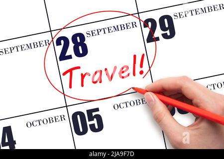 28th day of September. Hand drawing a red circle and writing the text TRAVEL on the calendar date 28 September . Travel planning. Autumn month. Day of Stock Photo